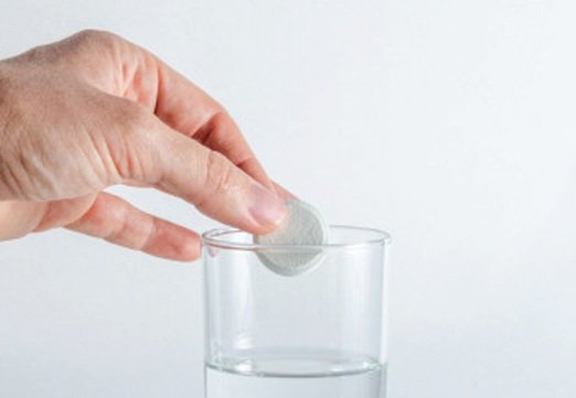 Private label effervescent tablets Effervescent tablet dissolving in a glass of water